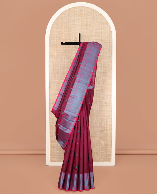 Wine Kanchipuram Silk Saree, Adorned with Mayil-Chakram Buttas All Over Its Body, Complemented by a Contrast Border of Thilakam, Banaras, Muthu, Rudraksham, Neli, and Vanki Designs, and Pallu Steeped with Kamalam Designs, and Paired with a Contrast Blouse
