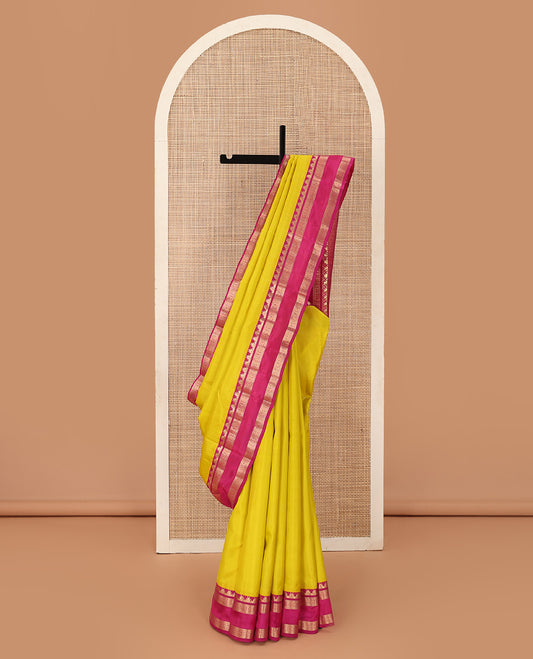 Lemon yellow plain Kanchipuram silk saree, contrast rettai pettu border of thazampoo rekku, neli, poo chakram, and kuthirai designs, and jaal pallu
