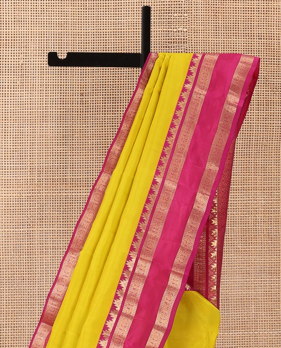 Lemon yellow plain Kanchipuram silk saree, contrast rettai pettu border of thazampoo rekku, neli, poo chakram, and kuthirai designs, and jaal pallu
