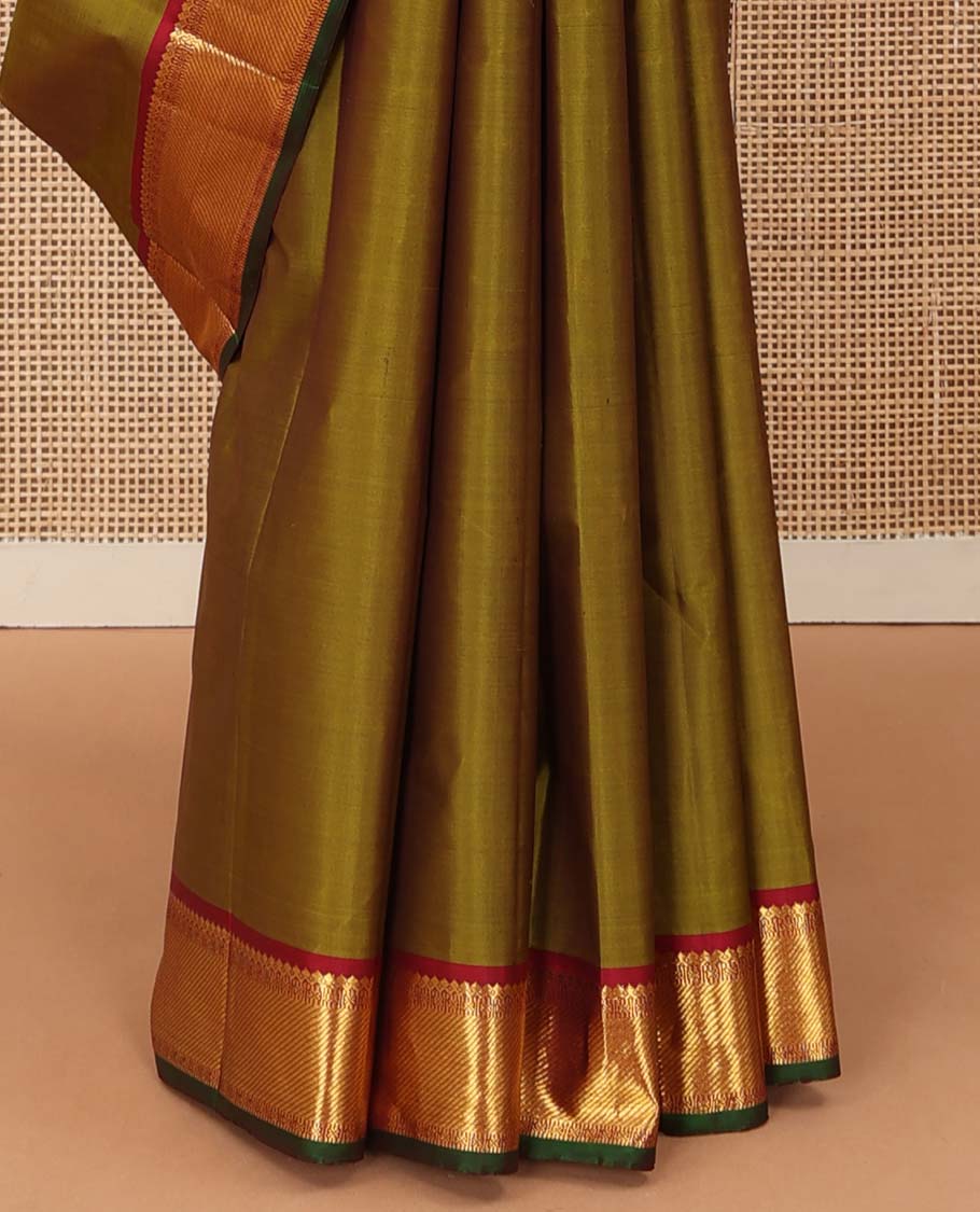 Green plain Kanchipuram silk saree, contrast border of thilakam mokku, muthu, cross kamalam, and zari stripes, and zari woven pallu