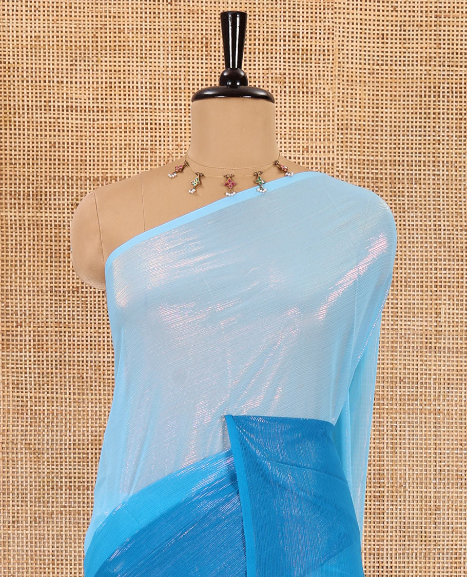 Borderless blue ombre-toned gleaming Shimmer Georgette saree, self-pallu with tassels and a plain blue blouse
