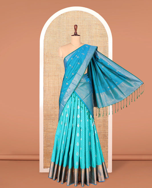 Blue Art Silk Material Half Saree Set, Adorned with Zari Buttas on Its Skirt, a Contrast Traditional Zari Design Border, Paired with a Matching Blouse, and a Dhavani Decorated with Zari Designs