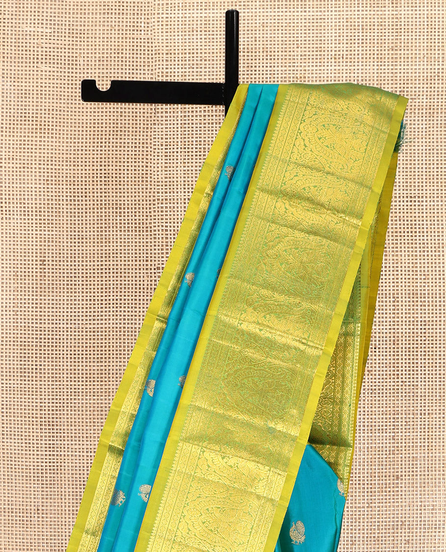 Blue Kanchipuram Silk Saree, Decorated with Mayil Buttas All Over Its Body, Complemented by a Contrast Border of Thilakam Mokku, Laddu Kamalam, and Mayil Designs, Pallu of Gandaberunda Designs, and Paired with a Contrast Blouse