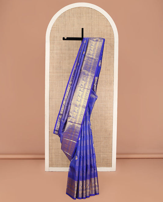 Blue Kanchipuram Silk Saree, Gleamed Up with Mayil Butta Enclosed Checks, Highlighted by One-Sided Border of Thilakam Mokku, Kamalam, Mayil, Chakram, and Rudraksham Designs, Pallu of Chakram and Mayil Designs, and Comes Without a Blouse