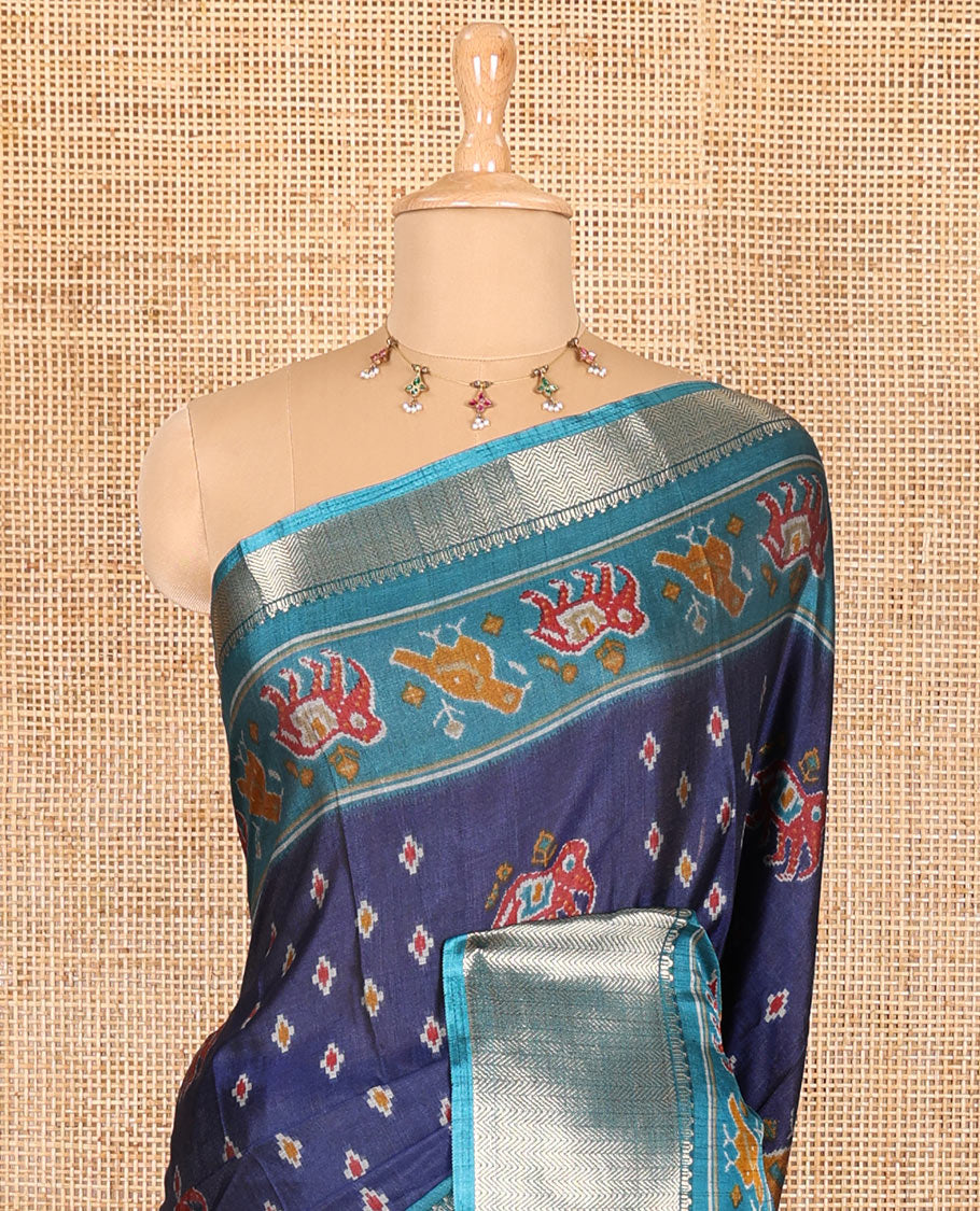 Navy blue patola elephant motifs printed Dola silk saree, contrast zari border, and pallu of animal patola motifs print, and a contrast butta printed blouse