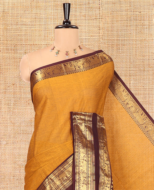 Mustard Plain Chettinad Cotton Saree, Complemented by a Contrast Rettai Pettu Zari Maroon Border of Temple, Coin, Elephant, and Peacock Designs, Subtly Striped Pallu, and Paired with a Matching Blouse