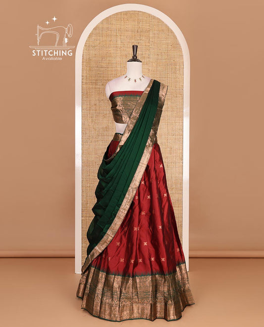 Maroon taffeta silk half saree, zari buttas with contrast green traditional zari border, matching zari blouse, and contrast plain zari border dhavani