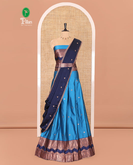 Light Blue and Navy Blue Semi-Banarasi Half-Saree Adorned with Zari Buttas on Its Skirt, Complemented by Contrast Traditional Zari Border of Chakram Designs, Paired with a Matching Blouse, and a Satin Georgette Embroidered Scallop Dhavani