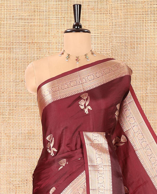 Wine Semi-Banaras Satin Silk Saree, Prettified with Floral Zari Buttas Across Its Body, Highlighted by Traditional Zari Design Border, Grand Zari Woven Palu of Jaal Designs, and Paired with a Matching Blouse