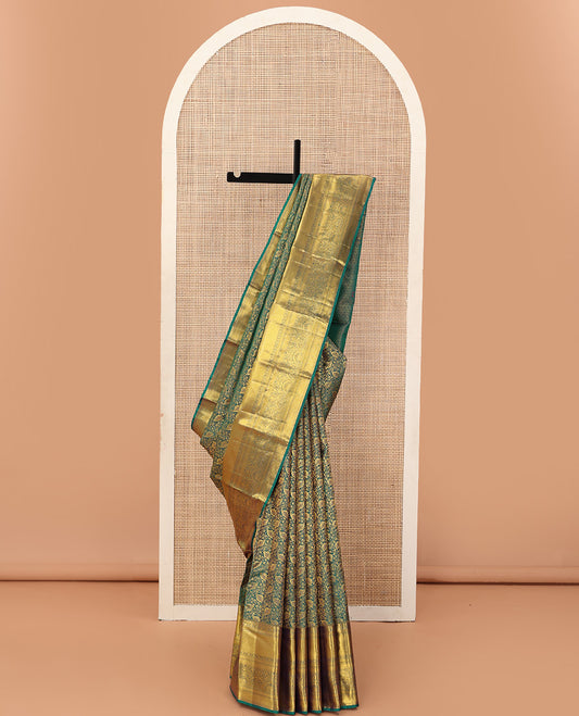 Green floral jacquard wedding silk saree, traditional zari border of thilakam mokku, kamalam, and mayil kann, and jaal pallu