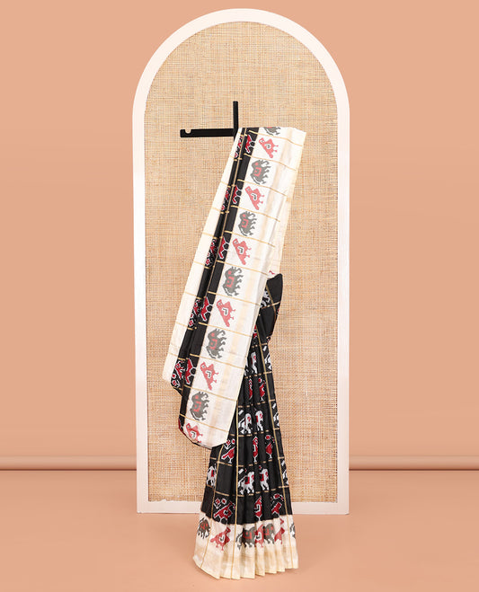 Black Ikkat Silk Saree, Impeccably Styled with Patola-Style Parrot-Elephant Butta Enclosed Checks on Its Body, Complemented by a Contrast Patola-Style Parrot-Elephant Butta Enclosed Border, Pallu of the Same Motifs, and Paired with a Contrast Blouse