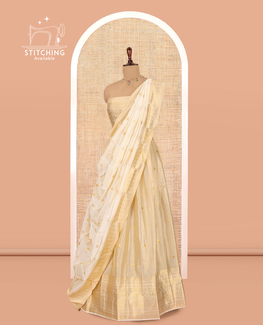 Cream Gold Tissue Half-Saree, Zari Buttas on Its Skirt, a Matching Blouse, an Intricately Zari-Designed Dhavani