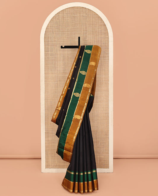 Black Kanchipuram Silk Saree, Mesmerized with Buttas and Vazhaipoo Stripes All Over Its Body, Complemented by a Contrast Border of Muthu, Kathir, and Arumbu Manga Designs, Sparsely Woven Pallu, and Paired with a Contrast Blouse