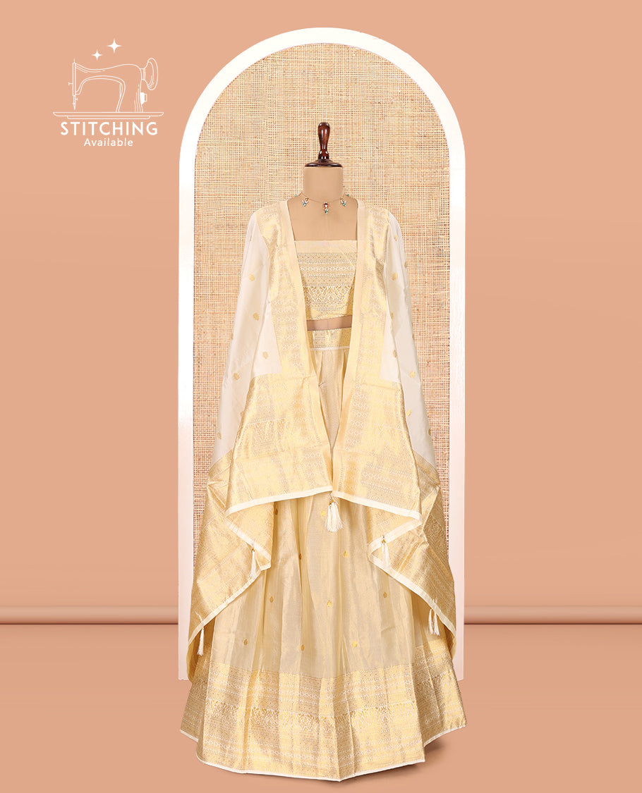 Cream Gold Tissue Half-Saree, Zari Buttas on Its Skirt, a Matching Blouse, an Intricately Zari-Designed Dhavani