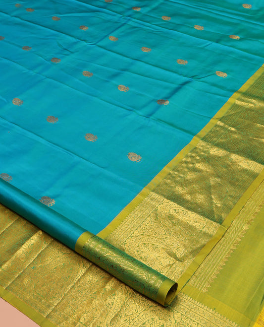 Blue Kanchipuram Silk Saree, Decorated with Mayil Buttas All Over Its Body, Complemented by a Contrast Border of Thilakam Mokku, Laddu Kamalam, and Mayil Designs, Pallu of Gandaberunda Designs, and Paired with a Contrast Blouse