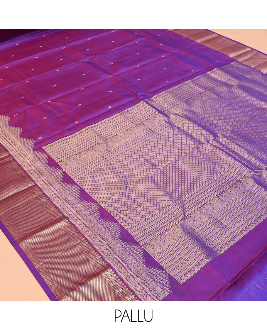Violet Vasundhara Silk Saree Gracefully Embellished with Zari Buttas, Highlighted by a Zari Border Featuring Thilakam Mokku, Muthu, Cross Kamalam, and Mayil Kann Designs, Elegantly Embellished Pallu, and Paired with a Matching Blouse