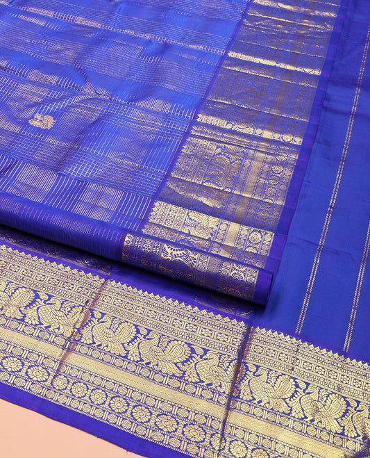 Blue Kanchipuram Silk Saree, Gleamed Up with Mayil Butta Enclosed Checks, Highlighted by One-Sided Border of Thilakam Mokku, Kamalam, Mayil, Chakram, and Rudraksham Designs, Pallu of Chakram and Mayil Designs, and Comes Without a Blouse