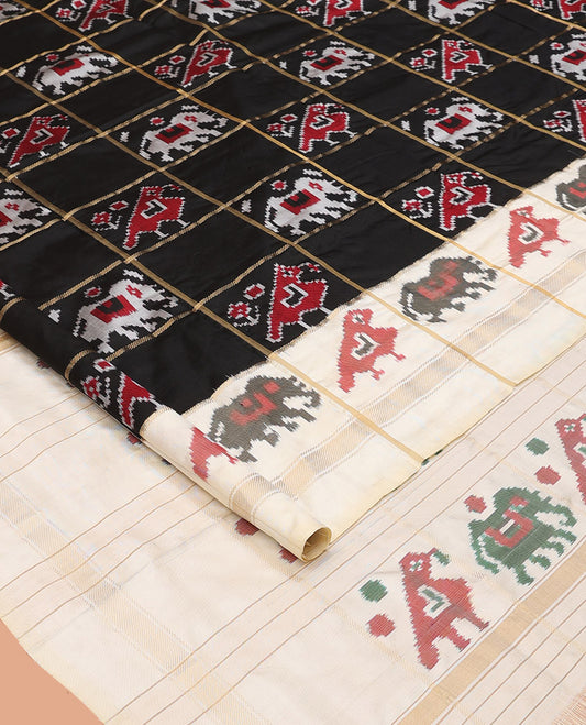 Black Ikkat Silk Saree, Impeccably Styled with Patola-Style Parrot-Elephant Butta Enclosed Checks on Its Body, Complemented by a Contrast Patola-Style Parrot-Elephant Butta Enclosed Border, Pallu of the Same Motifs, and Paired with a Contrast Blouse