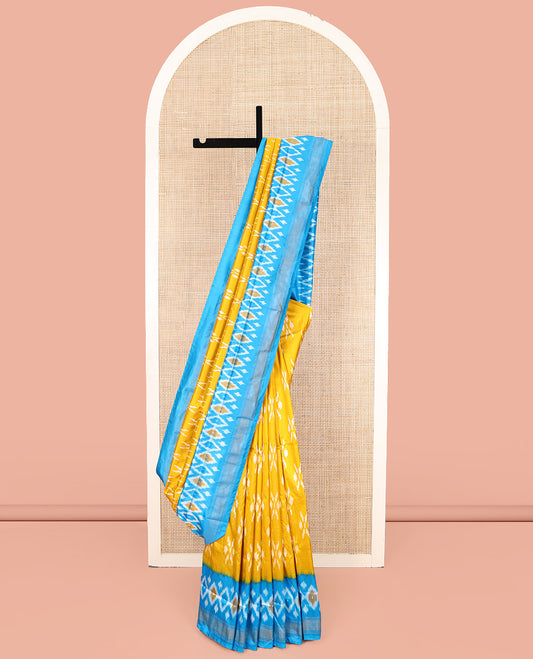 Mustard Ikkat Silk Saree, Masterfully Woven with Ikkat Buttas All Over Its Body, Complemented by a Contrast Diamond-Patterned Border, Pallu of Ikkat Butta Enclosed Checks, and Paired with a Contrast Blouse