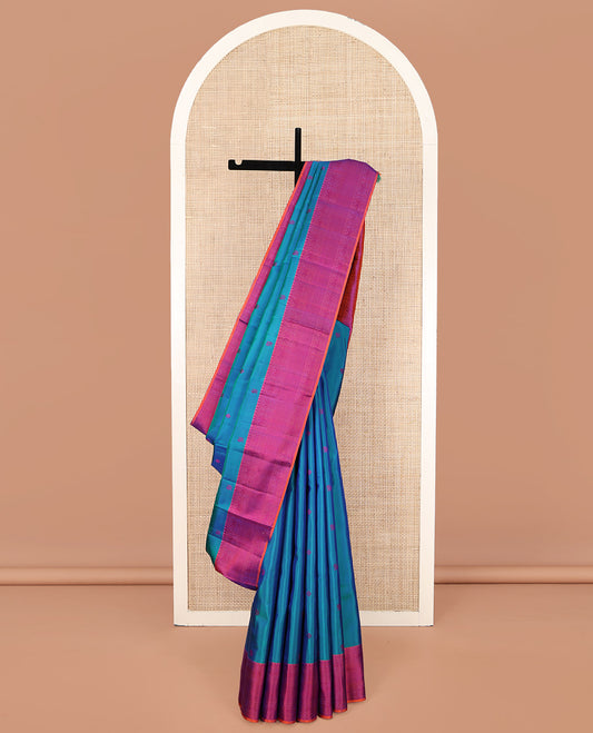 Blue Kanchipuram Silk Saree, Accentuated with Mayil-Chakram Buttas All Over Its Body, Complemented by a Contrast Border of Thilakam Mokku, Iruthalai Pakshi, and Kuyil Kann Designs, and Pallu of Jaal Designs, and Paired with a Contrast Blouse