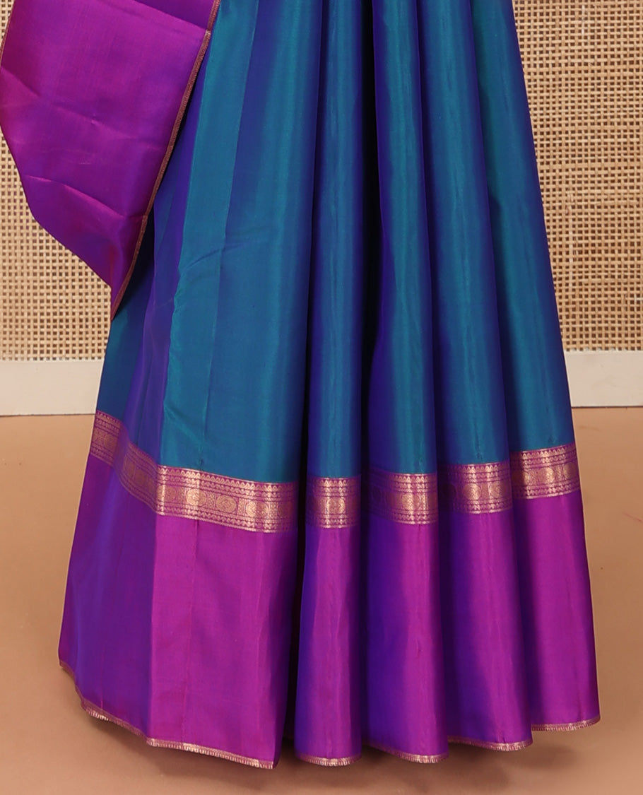 Blue plain Kanchipuram silk saree, contrast ganga jamuna rettai pettu border of rekku, neli, banaras, and rudraksham designs, and pallu of kathir, rudraksham, neli, poun, ara bogudi, and ara maadam