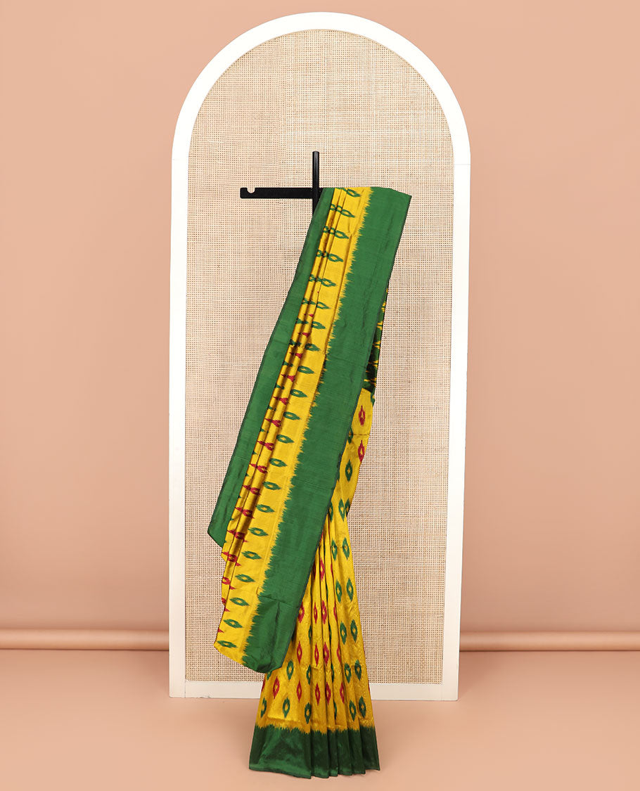 Yellow Ikkat Silk Saree Ornamented with Ikkat Buttas, Featuring a Contrast Plain Border, Complemented by a Pallu Ikkat Woven in an Ogee Pattern