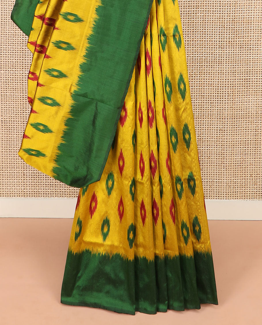 Yellow Ikkat Silk Saree Ornamented with Ikkat Buttas, Featuring a Contrast Plain Border, Complemented by a Pallu Ikkat Woven in an Ogee Pattern