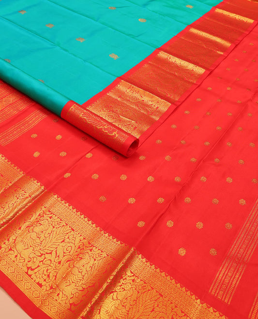 Turquoise mayil chakram buttas Kanchipuram silk saree, contrast border of thilakam mokku, cross kamalam, and mayil designs, and chakram design pallu