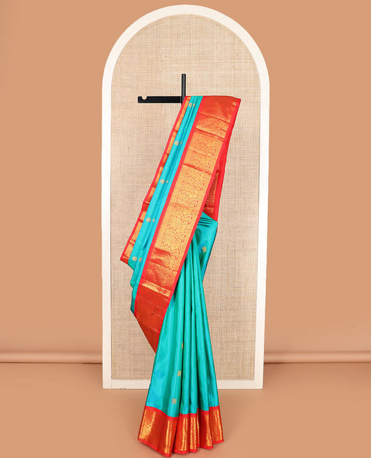Turquoise mayil chakram buttas Kanchipuram silk saree, contrast border of thilakam mokku, cross kamalam, and mayil designs, and chakram design pallu