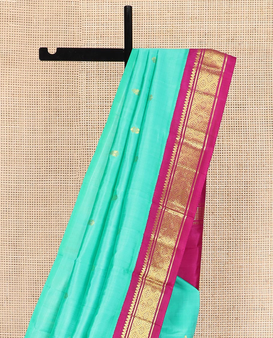Turquoise Kanchipuram Silk Saree Bedecked with Zari Buttas All Over Its Body, Complemented by a Contrast One-Sided Korvai Border of Thilakam Mokku, Banaras, and Jaal Designs, Pallu of Zari Designs, and Comes Without a Blouse