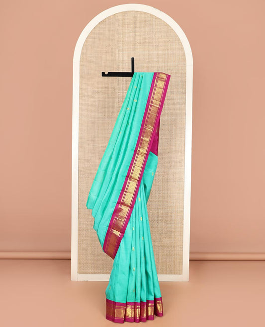 Turquoise Kanchipuram Silk Saree Bedecked with Zari Buttas All Over Its Body, Complemented by a Contrast One-Sided Korvai Border of Thilakam Mokku, Banaras, and Jaal Designs, Pallu of Zari Designs, and Comes Without a Blouse