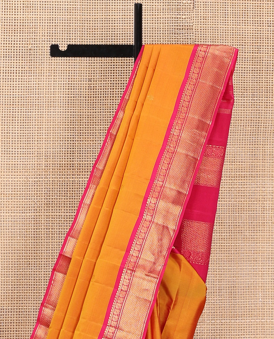Orange Kanchipuram Silk Saree Decked Up with Zari Buttas, Complemented by Contrasting Border of Rekku, Banaras, Mayil, and Mayil Kann Designs, Pallu Mirroring the Same Border Design, and Paired with a Contrast Blouse