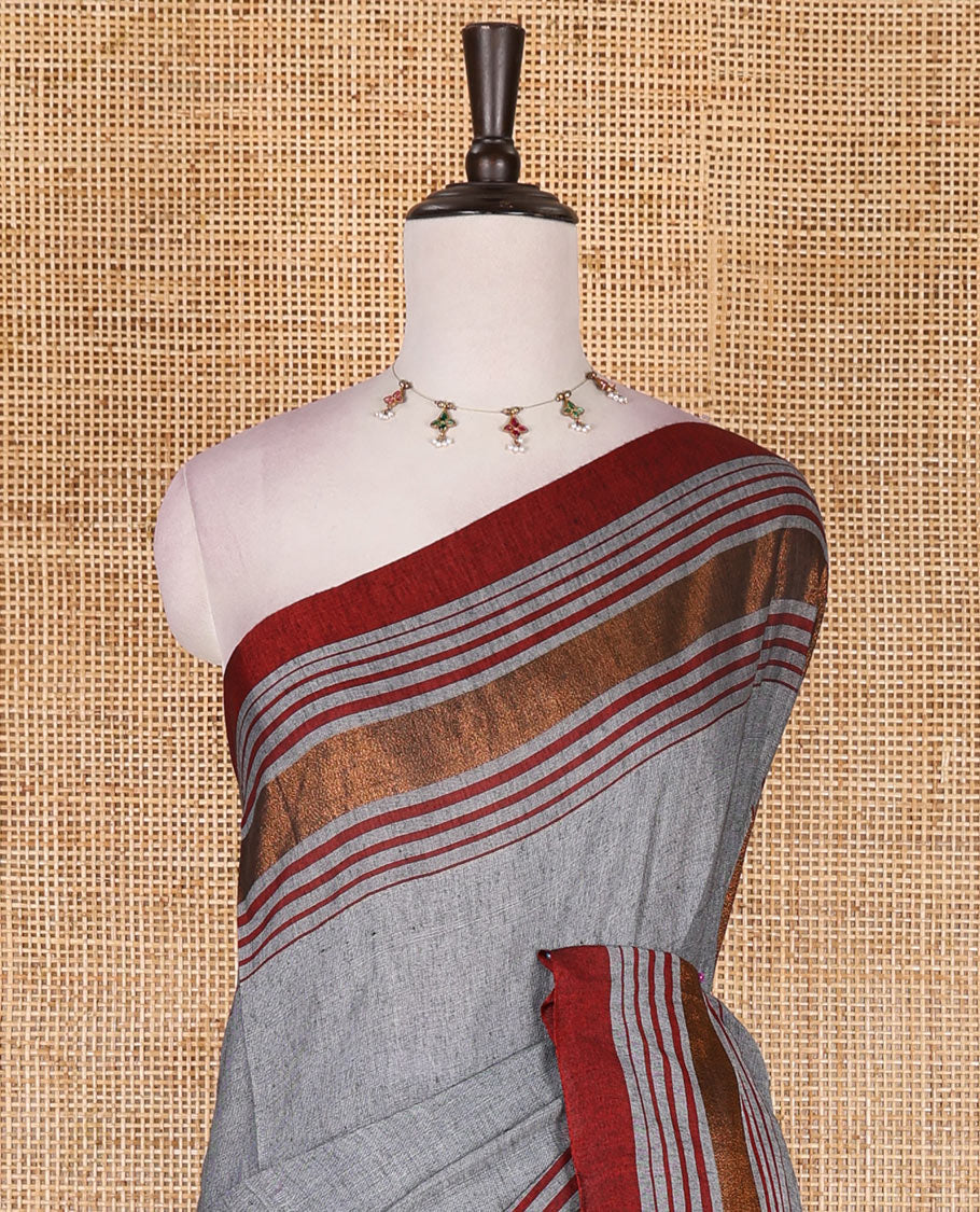 Grey-red plain design mul mul cotton saree, contrast copper zari horizontally striped border, plain pallu, and plain blouse