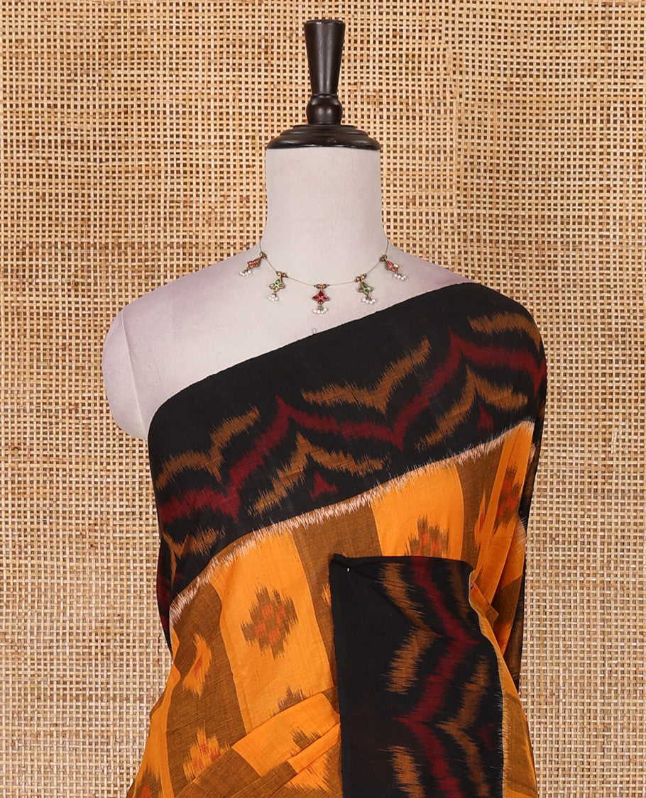 Mustard ikkat weaving ikkat cotton saree, contrast chevron design border, floral ikkat design pallu, and contrast plain blouse