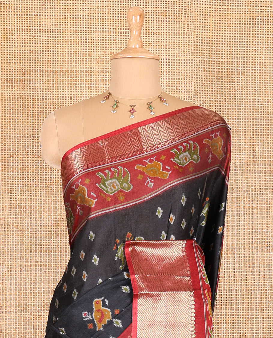 Black patola elephant motifs printed Dola silk saree, contrast zari border, and pallu of animal patola motifs print, and a contrast butta printed blouse
