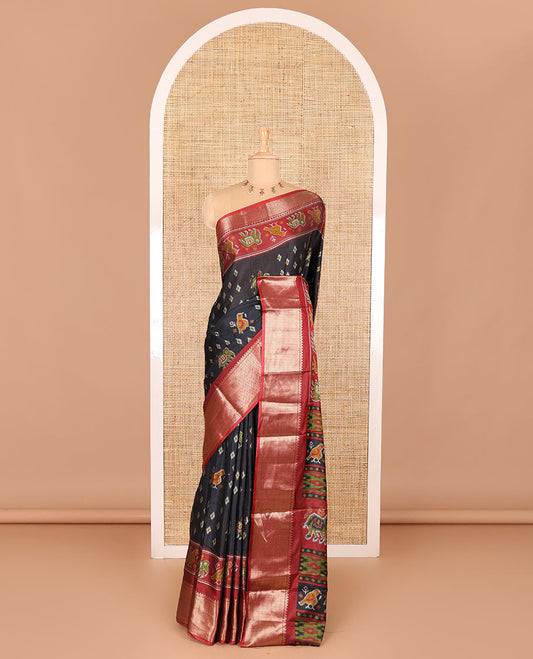 Black patola elephant motifs printed Dola silk saree, contrast zari border, and pallu of animal patola motifs print, and a contrast butta printed blouse