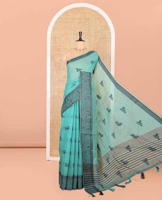 Rama Chanderi Cotton Saree Delicately Woven with Warli Motifs All Over Its Body, Featuring a Subtly Sparkled Border Depicting Warli Village Motifs, Subtly Striped Pallu, and Paired with a Matching Blouse