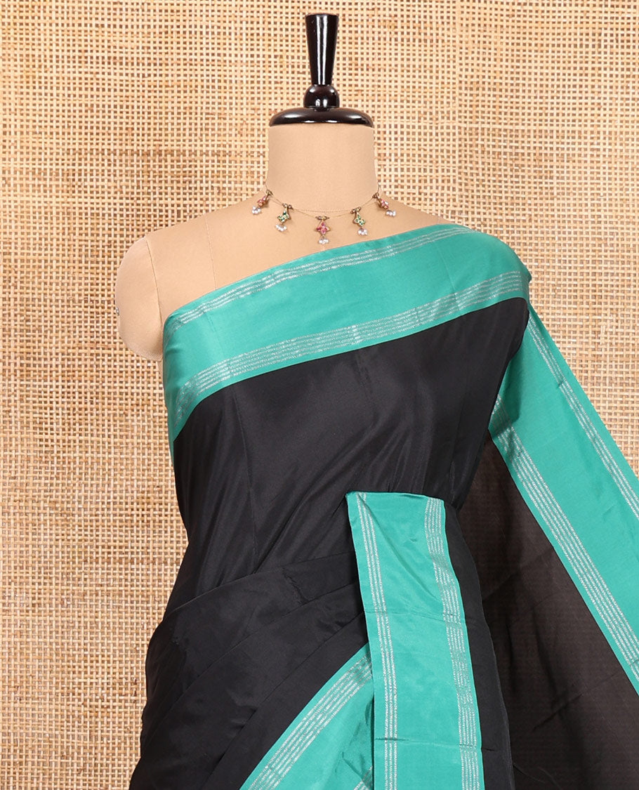 Black Plain Semi-Soft Silk Saree, Complemented by a Contrast Zari Striped Border, Pallu Features Stripes, and Paired with a Matching Blouse