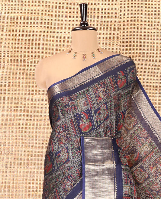 Navy Blue Dola Silk Saree Features Kalamkari Peacock-Human Print, a Traditional Zari Border, Printed Pallu, and a Matching Blouse