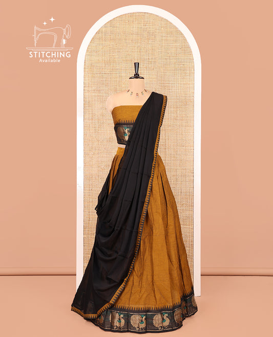 Mustard-Black Chettinad Cotton Half-Saree Set Featuring a Plain Skirt, Contrast Temple Peacock Motif Border, a Matching Blouse, and a Contrast Temple Dhavani