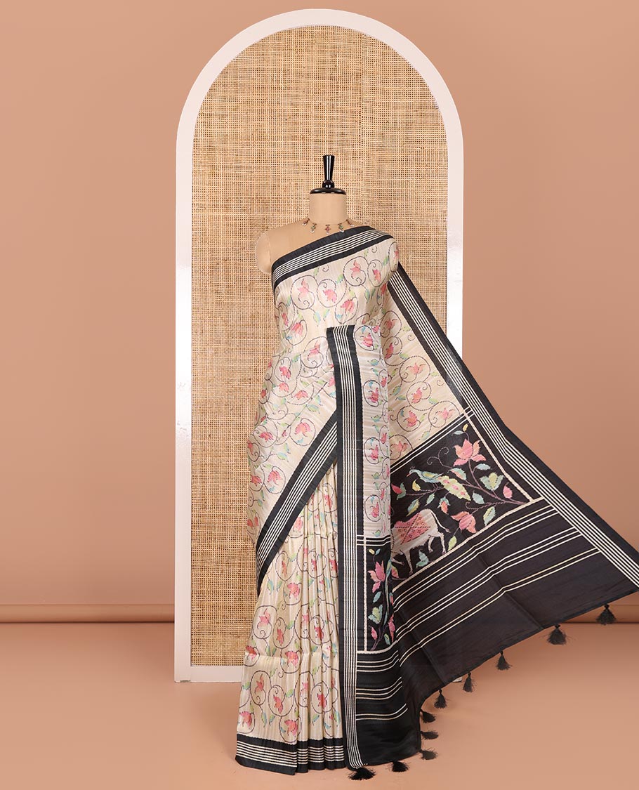 Chikku-black floral vine printed tissue patola saree, contrast striped border, pallu of floral and Pichwai cow motifs print, and a plain blouse