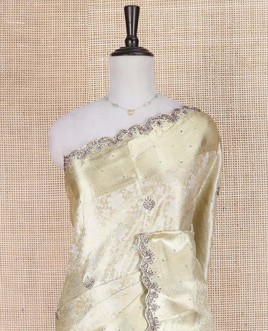 Cream Vastrakala Silk Saree, Enlivened with Floral Jacquard and Patch Stone Work, Highlighted by Traditional Zari and Intricate Stone Embroidered Scallop Border, Grand Jaal Design Stone Work Pallu, and Paired with Heavy Embroidered Blouse