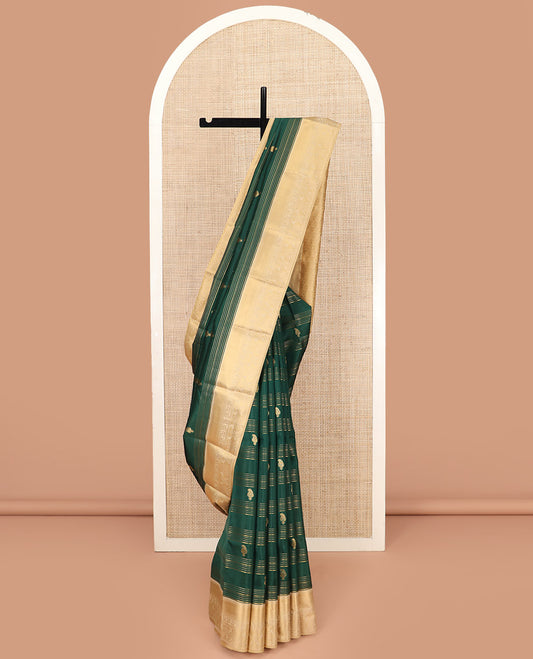 Green Vasundhara Lite Silk Mix Saree, Elegantly Highlighted with Zari Stripes and Manga Buttas All Over Its Body, Highlighted by Contrast Zari Border, Grandly Pallu Steeped with Thilakam Designs, and Paired with a Matching Blouse