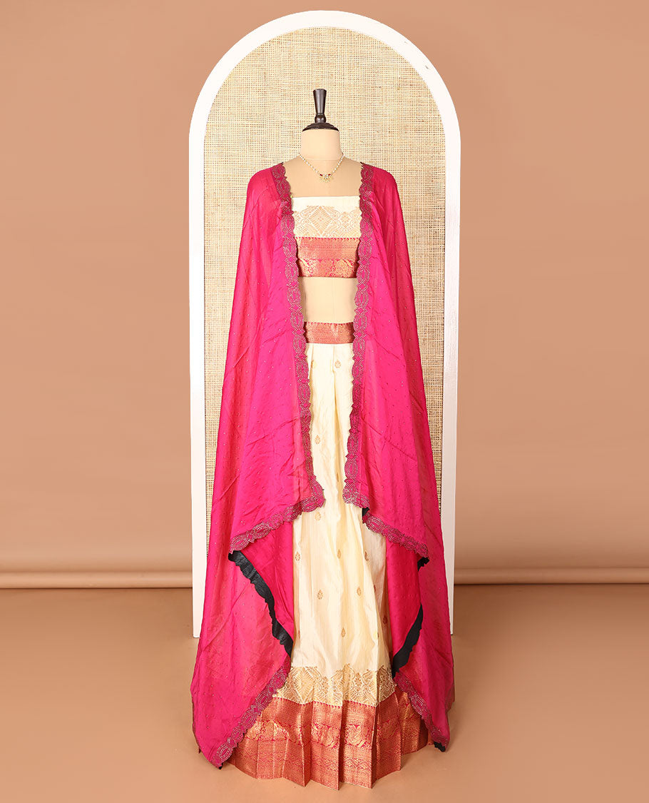 Cream-pink art-silk half-saree, zari buttas with contrast traditional design bordered skirt, a matching blouse, and scallop stone work dhavani