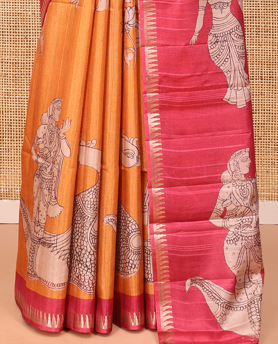 Orange Semi-Tussar Silk Saree, Artfully Detailed with Kalamkari-Style Human Motifs Printed on Its Body, Complemented by a Contrast Temple Zari Border, Creatively Kalamkari Printed Pallu, and Paired with a Contrast Blouse