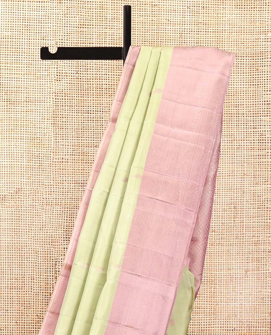 Pale Green Kanchipuram Designer Silk Saree, Subtly Sparkled With Buttas All Over Its Body Complemented by Contrast Traditional Designs Threaded Border, Subtly Woven Pallu, and Paired with a Contrast Blouse