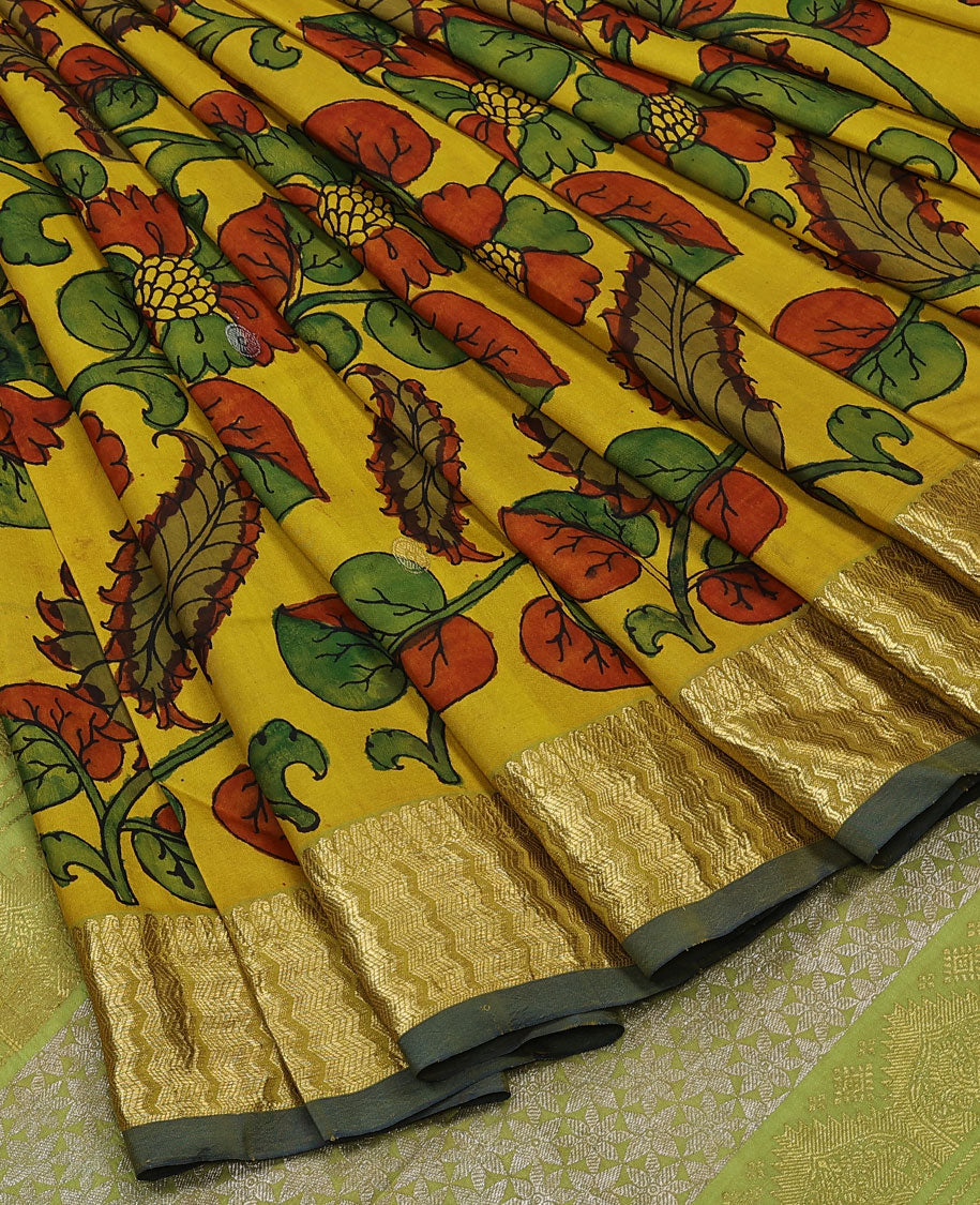 Yellow handpainted pen Kalamkari silk saree with floral design, contrast kanchi border & pallu of intricate floral jaal