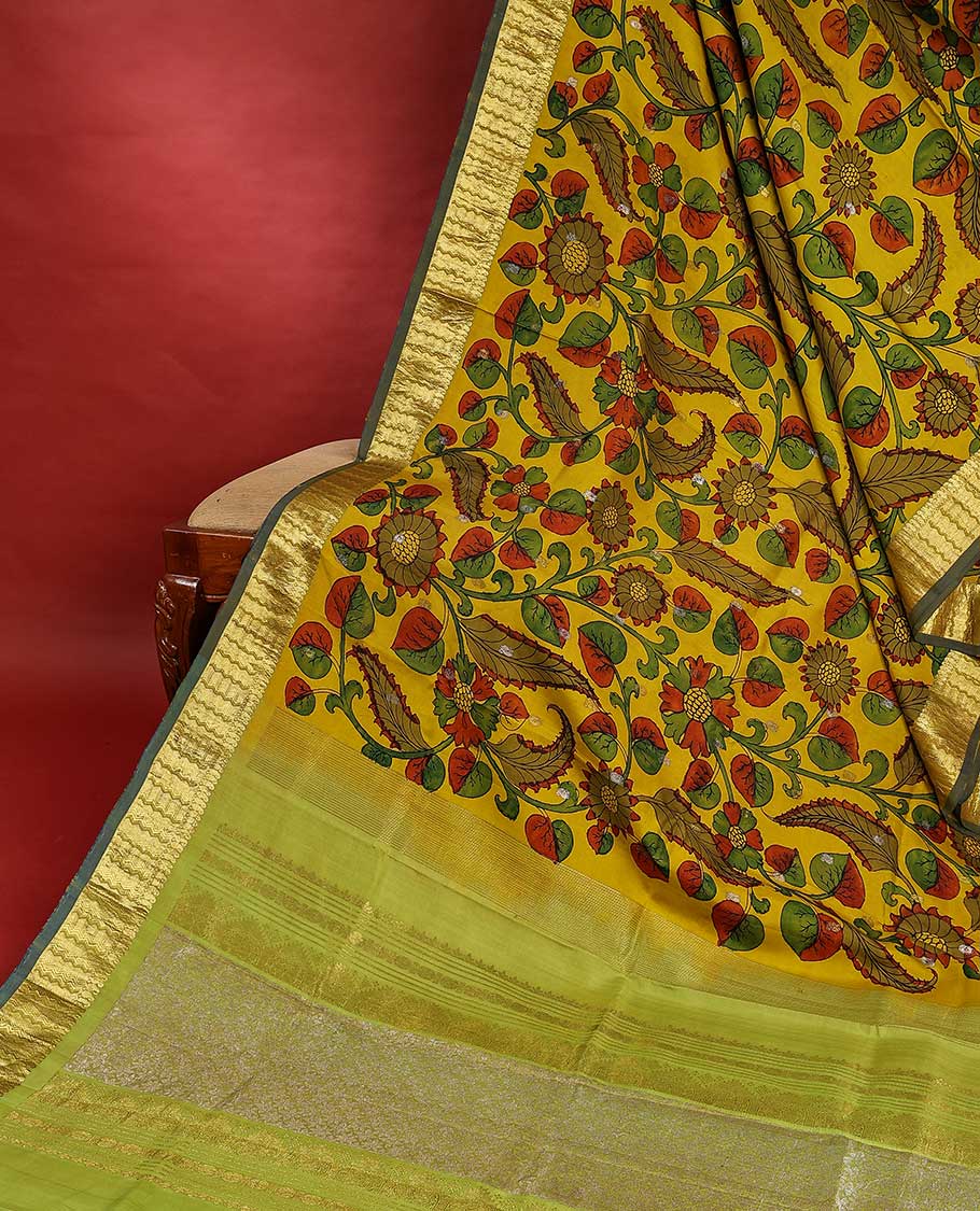 Yellow handpainted pen Kalamkari silk saree with floral design, contrast kanchi border & pallu of intricate floral jaal