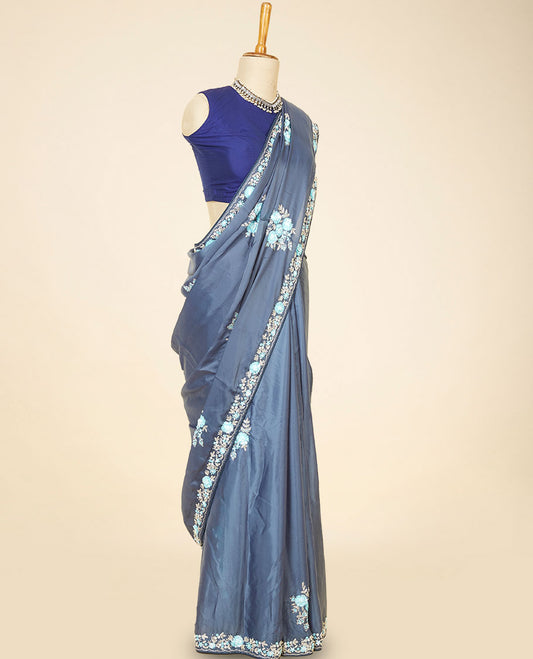 Grey embroidery satin silk saree bedecked with blue colour floral designs all over its body & pallu, embroidery border