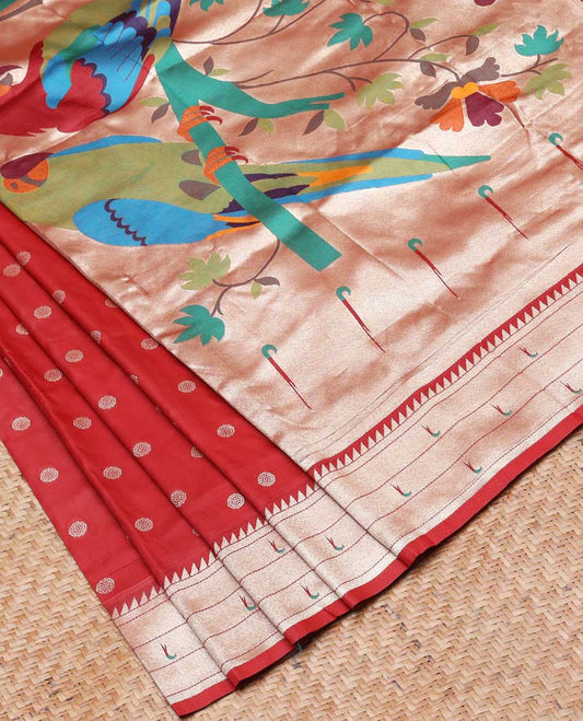 Red semi-paithani saree with buttas, contrast muniya border & pallu features multi-color floral vine & macaw parrots